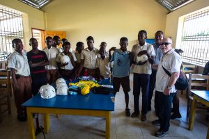 Eric with the students and the donated soccer balls and jerseys